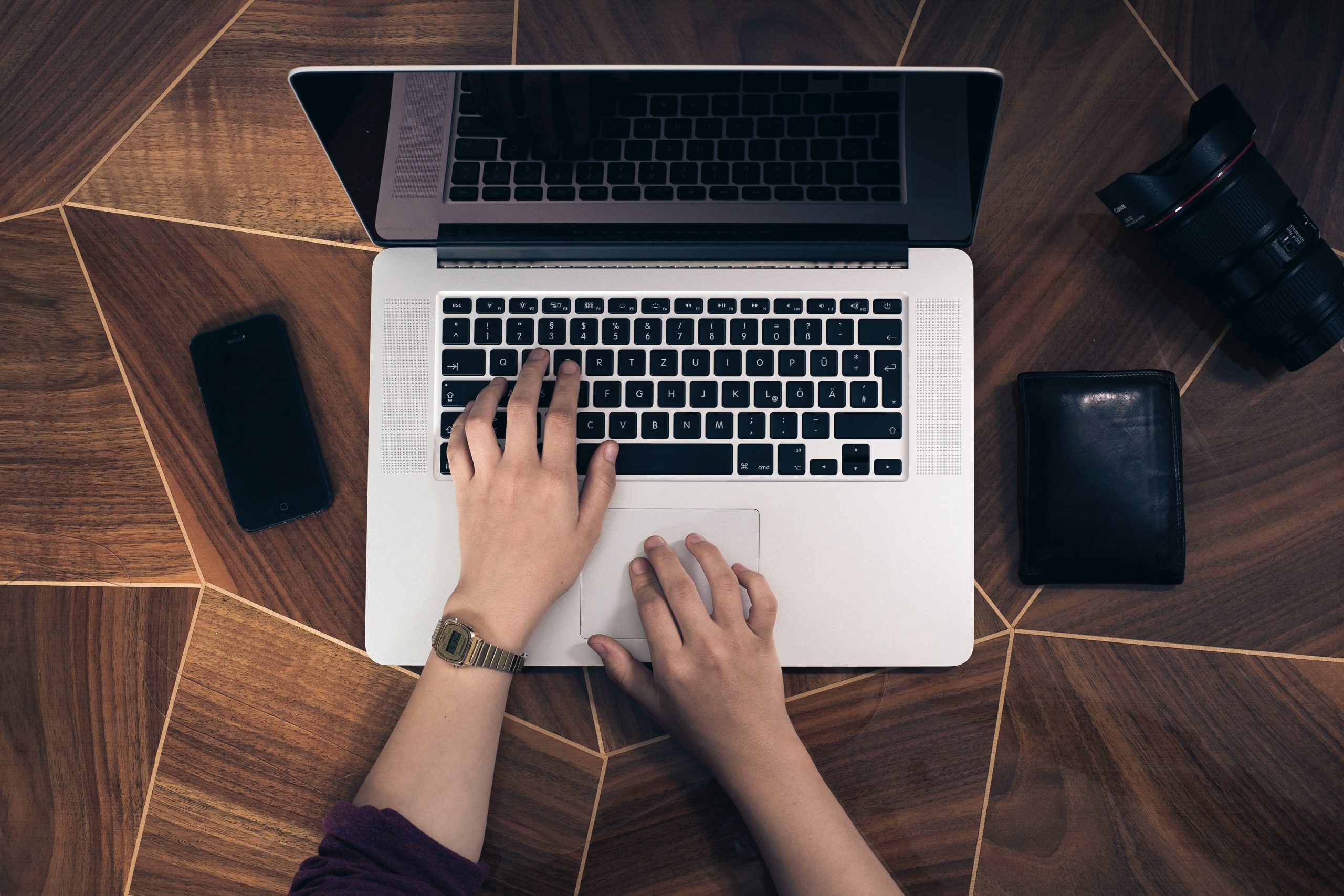 Des mains de femmes tapant sur le clavier de l'ordinateur portable ouvert.