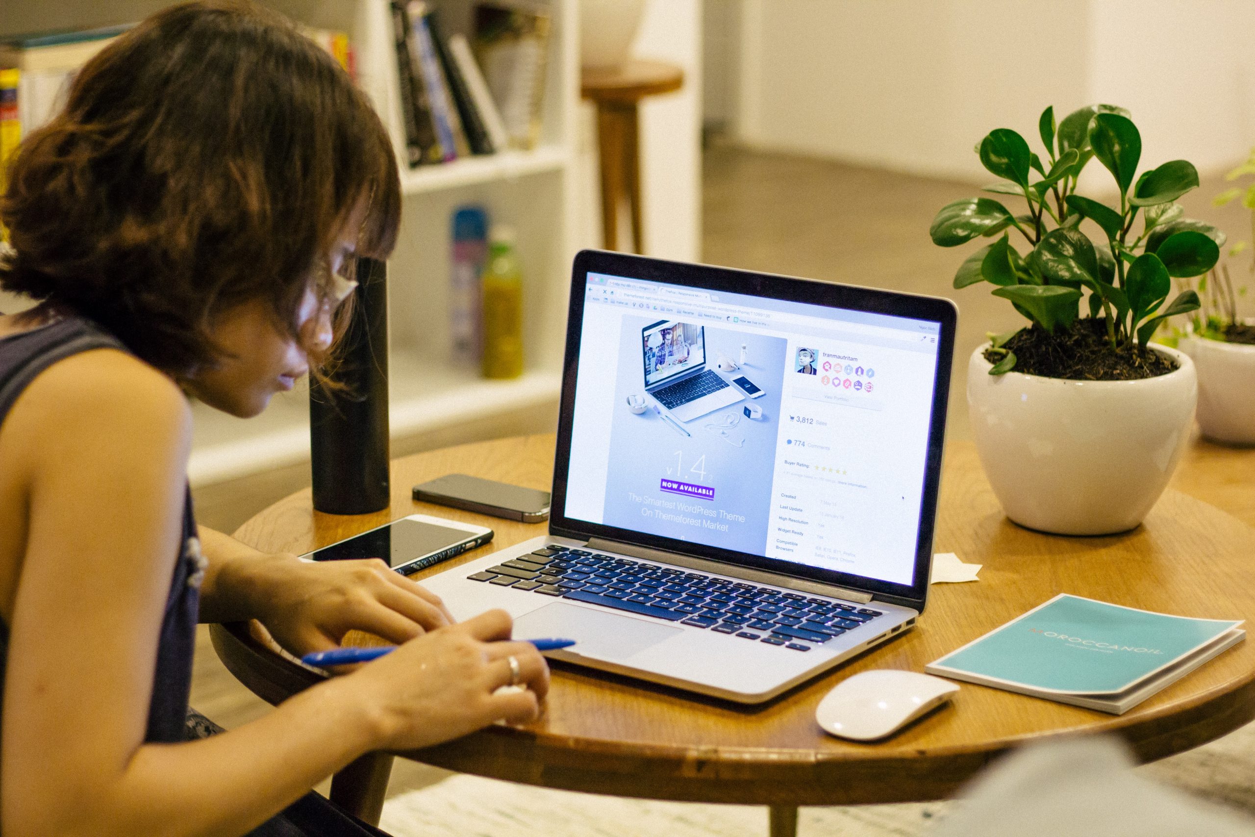 Une femme travaillant sur son ordinateur et qui crée  le design d'un site web.